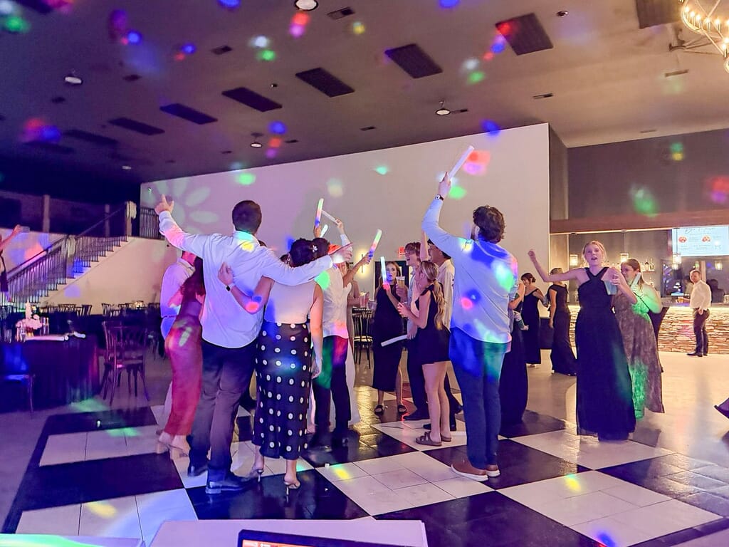 Gallery - Highbanks Wedding & Events Real Weddings 12 Guests dancing on the checkered dance floor with glow sticks at a Highbanks wedding.