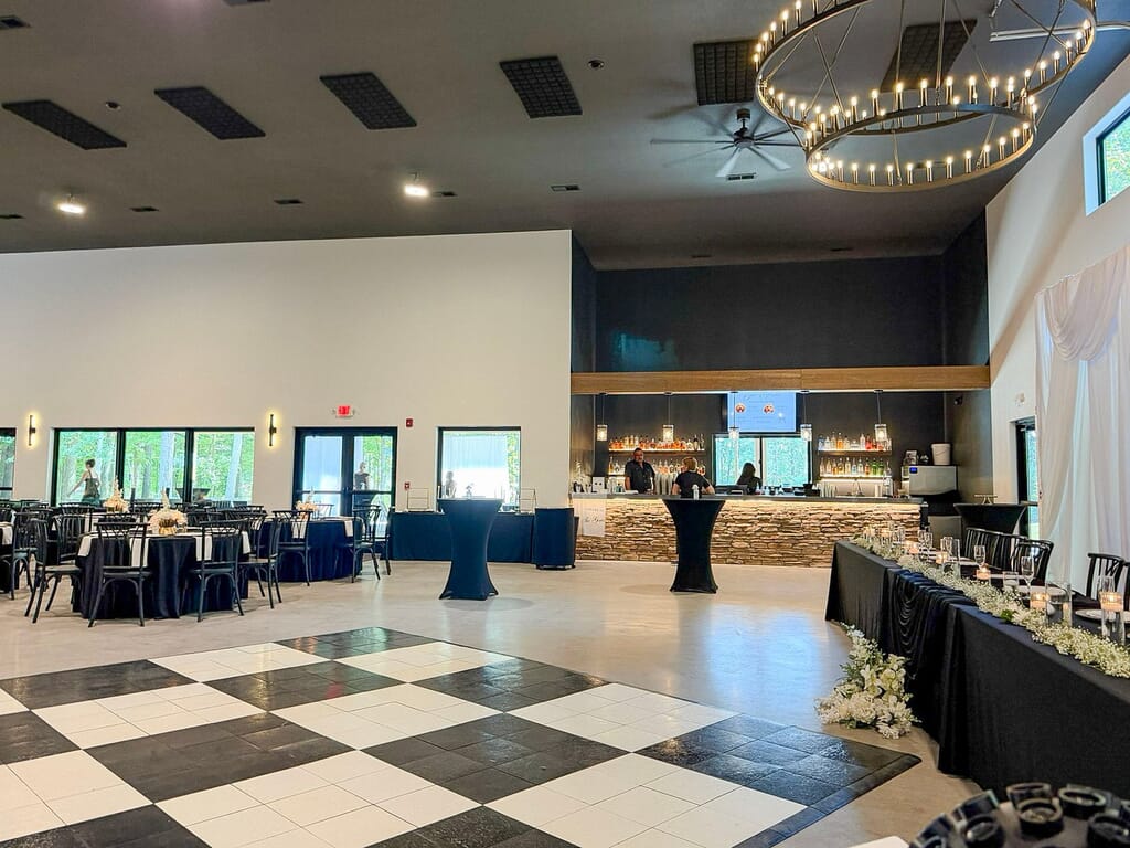 Gallery - Highbanks Wedding & Events Real Weddings 1 Event space at Highbanks Wedding & Events with a black and white checkered dance floor, black-linen tables and a stone-faced bar.