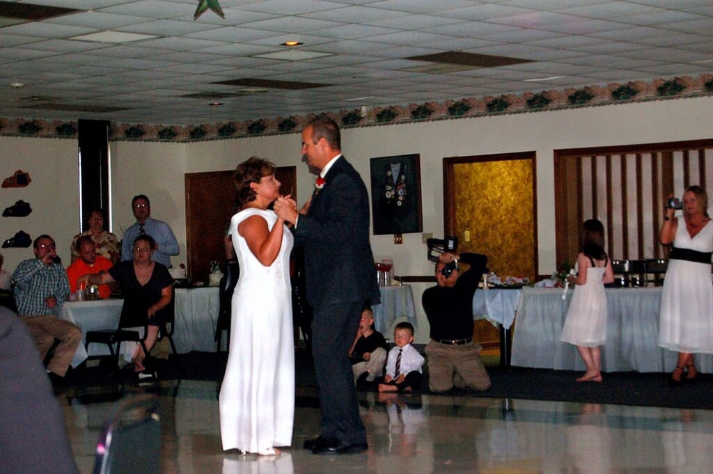 Madisonville Kentucky Wedding DJ 16 Bride and groom slow dancing at their wedding reception with guests and a videographer looking on.
